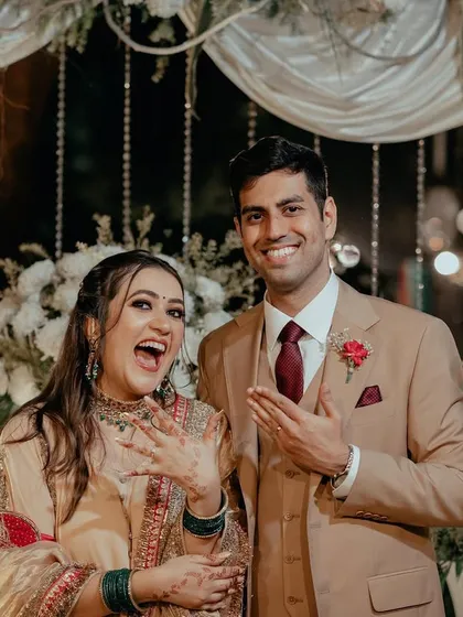 The couple proudly shows off their new rings after their intimate engagement ceremony, their faces beaming with happiness.