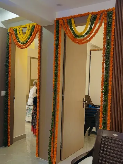 Simple marigold torans (garlands) used to decorate the doorways inside a house, creating a traditional and connected feel throughout the space.