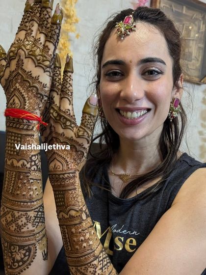 The joy on a bride's face is the best reward. Here she is, smiling and showcasing her detailed bridal back-hand mehndi.