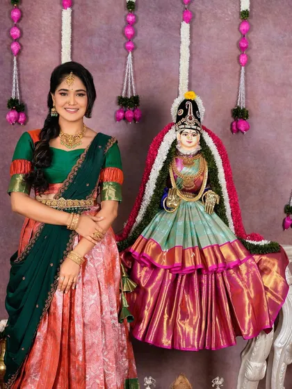 The model standing next to the decorated deity, showcasing a complete festive look with our jewellery.