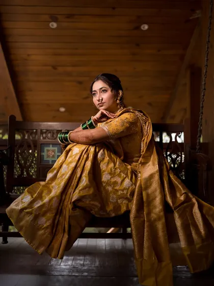 A relaxed and stylish pose on a traditional wooden swing, showcasing the bride's confident energy.