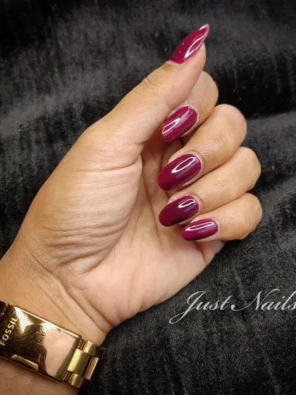 A classic, deep red manicure on almond-shaped nails. A timeless choice that is always elegant.