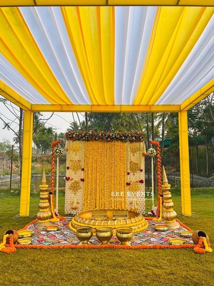 Another angle of the beautiful outdoor Haldi setup. The canopy provides shade while maintaining an open and airy feel, and the decor is rich with traditional elements like marigold garlands and brass props.