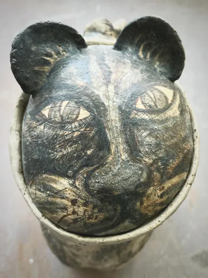 A bit of fun with a cat-faced pot. I enjoy creating whimsical pieces that bring a smile. This one is hand-sculpted and painted, perfect for a quirky planter or just as a unique decorative object.