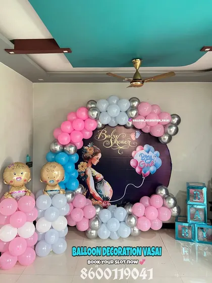 This circular backdrop for a baby shower uses a classic pink, blue, and silver color scheme. The design is completed with baby-shaped foil balloons and transparent "BABY" blocks for extra charm.