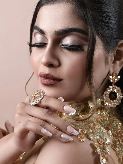 Details matter. This shot highlights the soft, shimmery eyeshadow and perfectly manicured nails that complete the look.