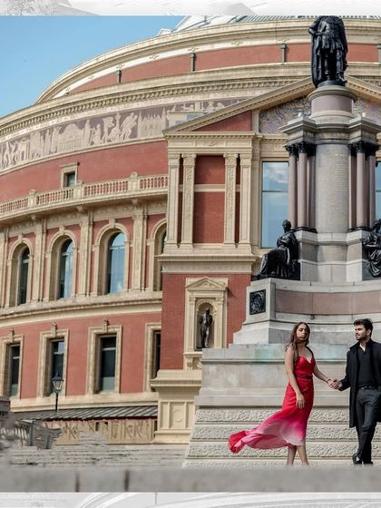 A beautifully composed wide shot where the couple holds hands on the monument steps. The bride's red dress provides a vibrant pop of color against the historic stone architecture.