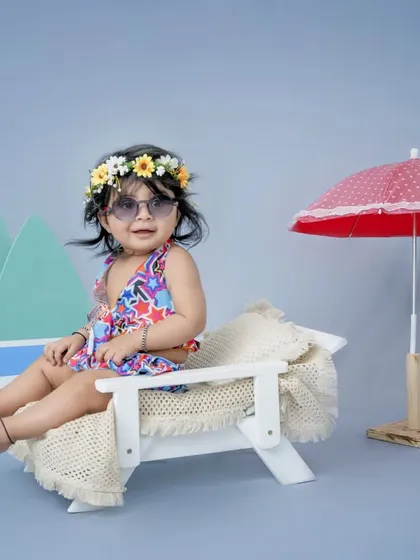 A day at the beach, right here in my studio. This little girl is ready for sun and sand, lounging on a miniature beach chair with surfboards and a parasol.