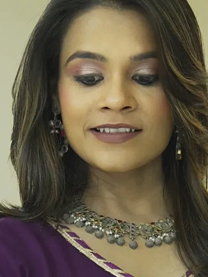 A photoshoot for a beautiful clothing brand. The makeup is soft and romantic, with a focus on purple and pink tones.