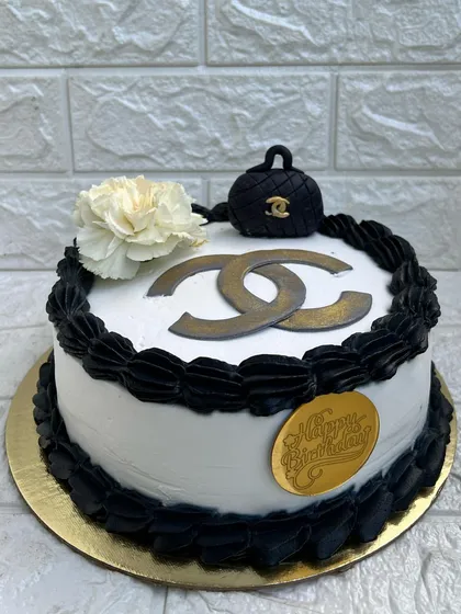 For the fashionista's birthday, a chic Chanel-themed cake. This White Truffle cake features the iconic logo, a miniature fondant handbag, and a classic black and white color palette.