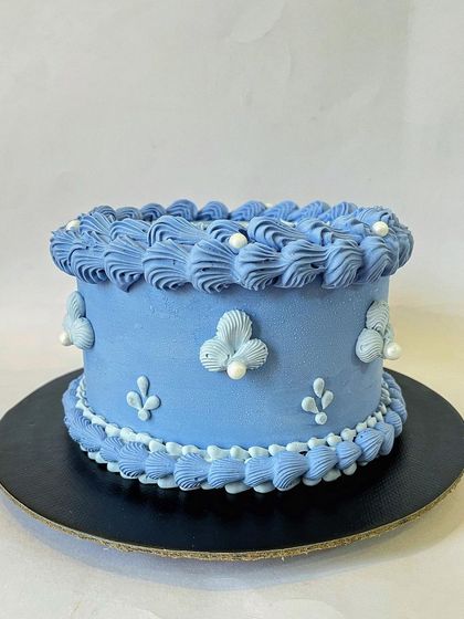 Vintage is back! This cake features intricate, hand-piped buttercream details in a classic Lambeth style. It's a timeless design that brings a touch of old-world elegance to any event.