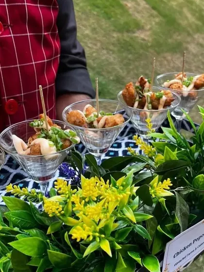 We ensure your guests are treated with impeccable service from the moment they arrive. Our staff serves a delightful array of pass-around appetizers, like these crispy chicken popcorn bites presented in stylish martini glasses.