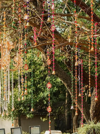 A closer look at the hanging decor, showing the intricate details of the colourful tassels and bells alongside a sparkling chandelier. It's a beautiful fusion of traditional and modern elements.