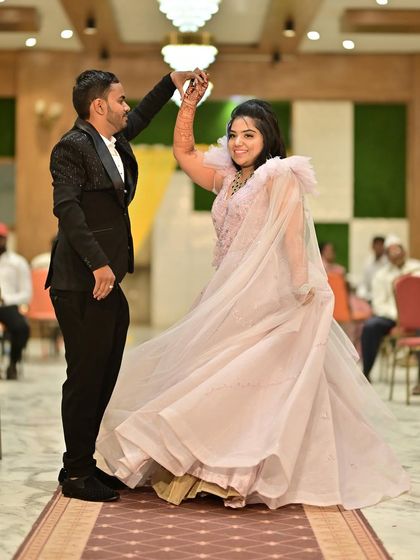 A joyful dance between the newly engaged couple. The bride-to-be's light pink gown flows beautifully as she twirls with her partner.