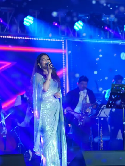 The full look on stage, where the saree creates a stunning, fluid silhouette.