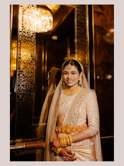 A stunning portrait of a Sabyasachi bride in an elevator, the golden light making her glow.