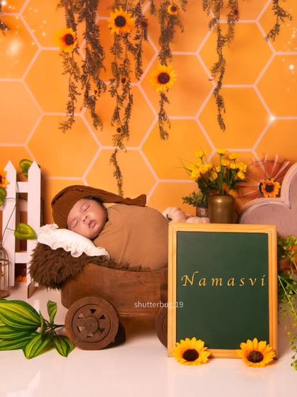 We can add a personal touch with a small chalkboard displaying the baby's name. This shot shows the baby sleeping in a wooden wagon as part of the sunflower theme.