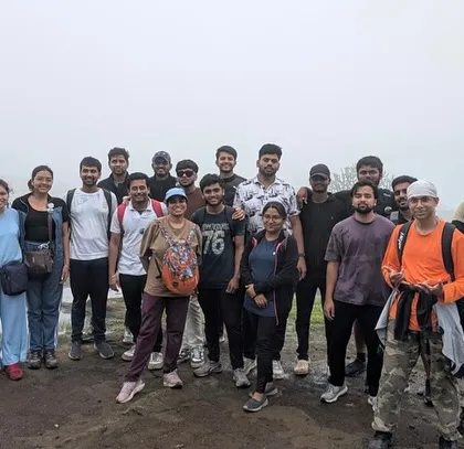 A group of trekkers on the misty trails of Harishchandragad, a historic hill fort in Maharashtra.