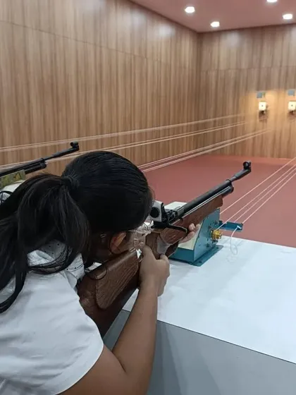 A young shooter concentrates on her target. The focus required for this sport is immense, and our sessions are designed to help you develop that mental clarity in a controlled and supportive setting.