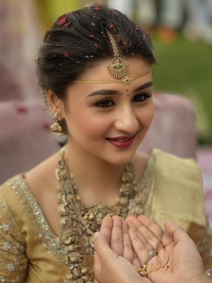 A close-up of the bride receiving the mangalsutra. Her expression is one of pure joy, and her makeup looks flawless and fresh.