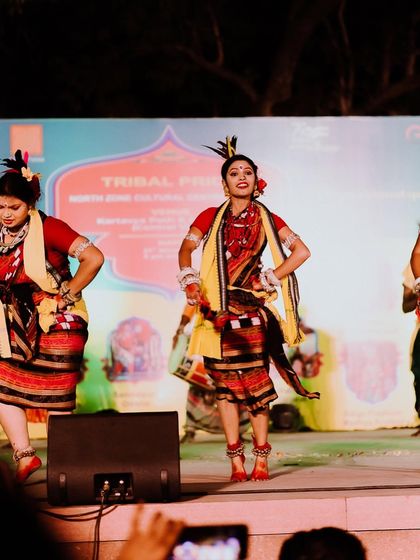A wide shot of a "Tribal Pride" cultural dance event, showing the performers on stage. This gives a sense of the scale and vibrant atmosphere of the celebration.