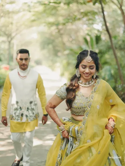 A playful moment from Tanisha's Haldi event in Raipur. Her yellow and green lehenga was complemented by a soft, romantic makeup look and a half-up hairstyle.