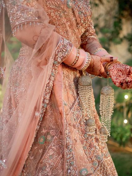 It's all in the details. A close-up of the intricate lehenga, henna, and kalire, with makeup that ties the whole look together.