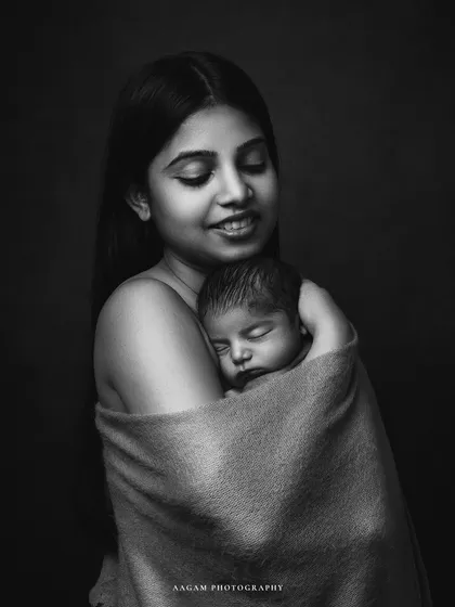 The gentle embrace of a mother. This black and white portrait is filled with serenity and tenderness, a timeless image of the maternal bond.
