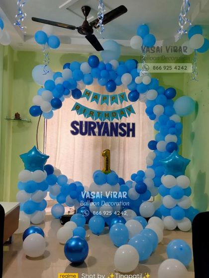 A beautiful blue and white theme for Suryansh's first birthday. This indoor setup features a balloon arch, star-topped pillars, and a personalized banner, showing how we can transform a home space for a celebration.