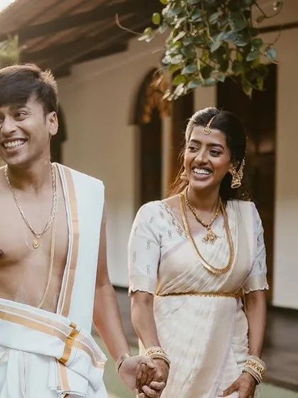 A happy couple walks hand-in-hand, bathed in the golden light of the morning sun.