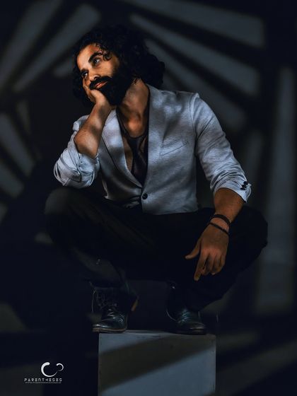 A pensive, thoughtful pose within the spiral of light. This portrait captures a moment of quiet reflection, showcasing a softer, more introspective side.