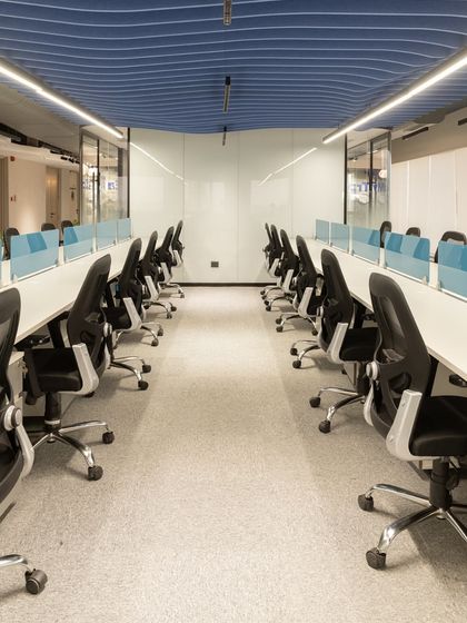 I designed the workstation layout for optimal flow and efficiency. Clean white desks are paired with ergonomic chairs and separated by light blue partitions, providing a sense of personal space within the open plan.