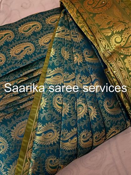 A stunning teal saree with a gold paisley print. The pleats are done to ensure the pattern flows beautifully.