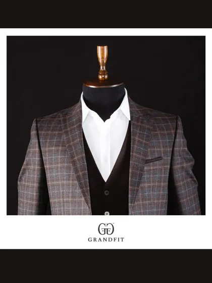 A detailed shot of the brown and blue plaid jacket, focusing on the interplay of colors within the pattern and the sharp cut of the lapels.