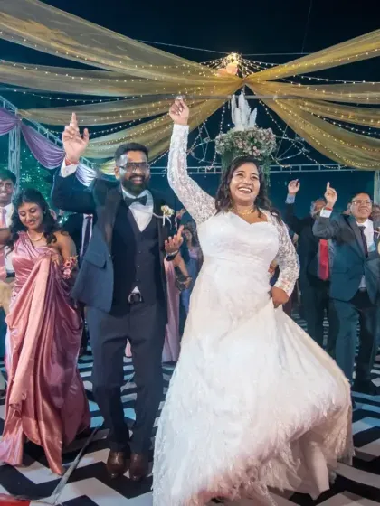 This is what a celebration looks like! The bride and groom leading their guests on the dance floor, with everyone's hands in the air. I aim to capture the collective joy of your wedding reception.