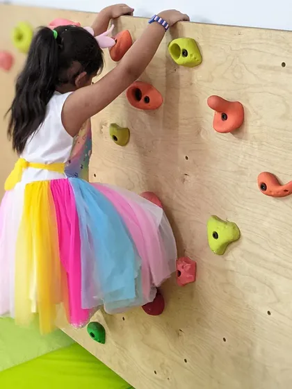 Our indoor climbing wall is a favorite spot for children to channel their energy. As this young girl navigates her path up the wall, she is developing strength, balance, and problem solving skills, all while having fun.