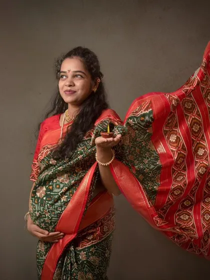 A dynamic shot of a beautiful mom-to-be in a traditional saree. The flowing fabric adds a sense of movement and grace to this classic portrait.