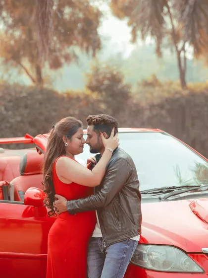 A romantic and intimate pose with a vibrant red convertible, perfect for a stylish and cinematic pre-wedding shoot.
