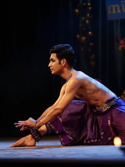 A moment of quiet contemplation during a performance, surrounded by the gentle light of diyas. This setting is perfect for intimate gatherings where the focus is on subtle expression.