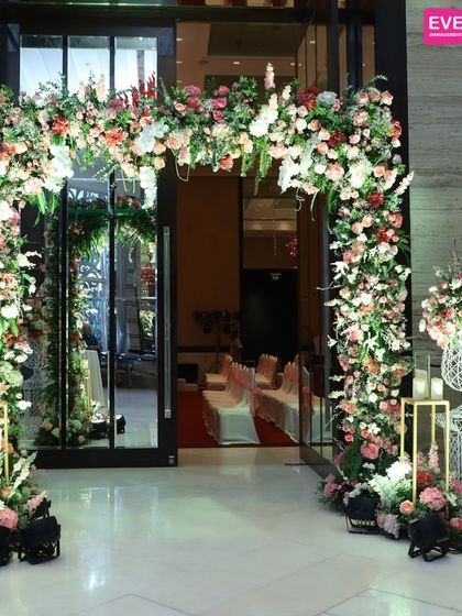 This entrance uses a beautiful arch of pink, peach, and white florals to create a soft and inviting passageway. It’s a perfect example of classic romance and elegance for a reception at the Taj Santacruz.