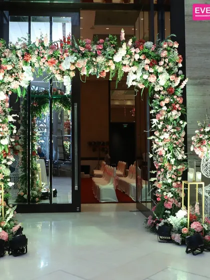 A beautiful floral archway in shades of pink and white creates a classic and romantic entrance, perfect for welcoming guests to a wedding reception.
