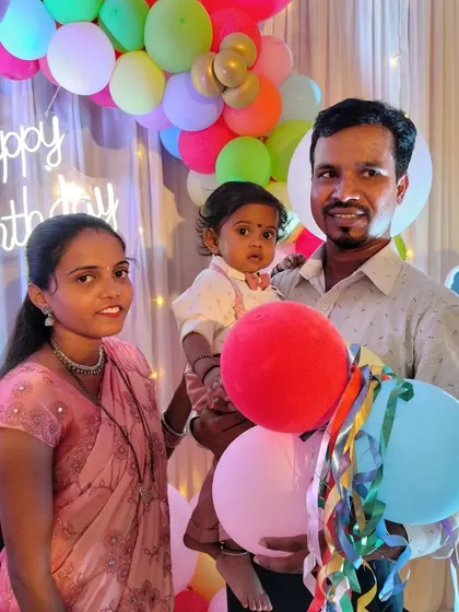 A happy family photo from Kriyansh's first birthday. Our Cocomelon themed decoration with a fairy light curtain and neon sign provides a beautiful backdrop for family portraits.