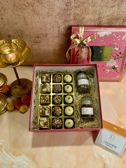 A beautiful pink Diwali gift box containing an assortment of our healthy, handmade Indian sweets and two small jars of our super seed mix and dried cranberries.