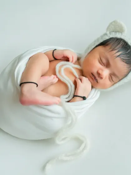 This classic 'potato sack' pose is a favorite for showing how tiny and curled-up newborns are. My training in safe newborn posing ensures your baby is always secure and comfortable.