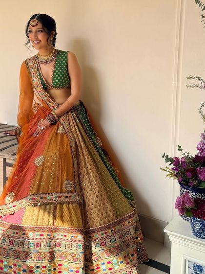 The full look of the bride in her colorful Sabyasachi lehenga, her marigold braid adding to the festive vibe.