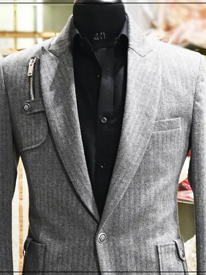 A grey blazer with a unique zipper detail on the lapel. This is an example of how I can add modern, edgy details to a classic piece.