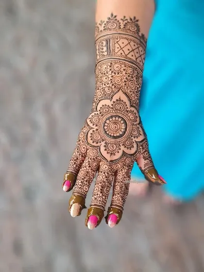 A full mandala session, with a large, detailed flower mandala on the palm and a matching cuff design on the wrist.