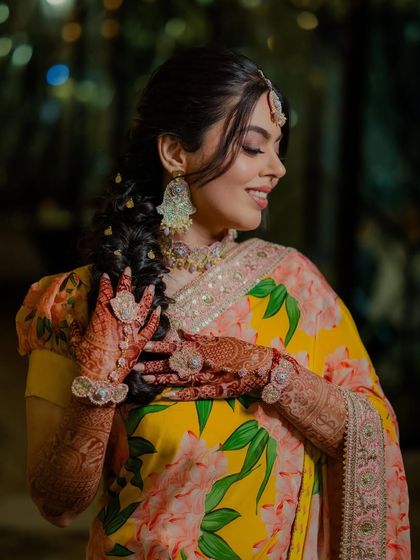 A close-up on the details. The soft makeup and intricate henna are a perfect match, creating a look of timeless elegance for her Haldi.