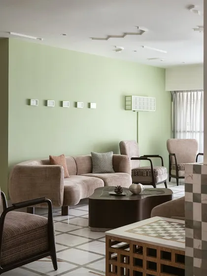 A pop of apple green on the wall marks the arrival at our 'Gingham Dreams' project. The sitting area features a duo of armchairs and a unique light-box style floor lamp that we had fixed to the wall per our client's request.