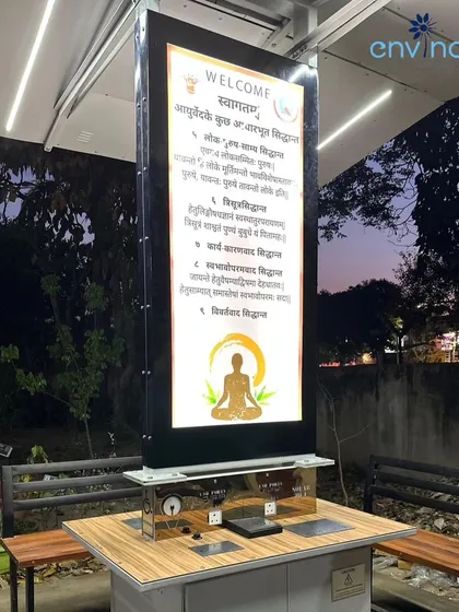 A close-up of the illuminated digital screen on our solar hut in Chandigarh at dusk. The screen displays welcome messages and important information, blending seamlessly with the modern aesthetic of the unit.